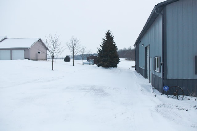 snowy yard with a detached garage