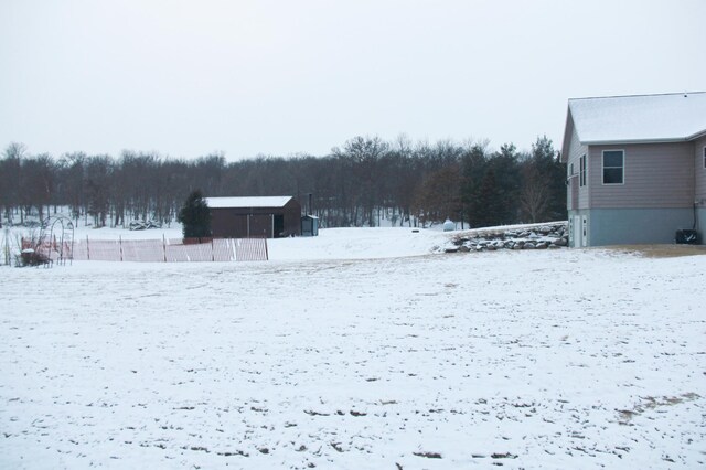 yard layered in snow featuring a detached garage