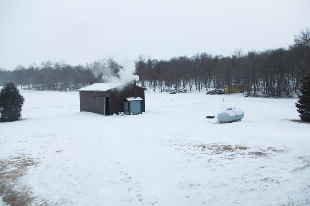 yard layered in snow with a wooded view