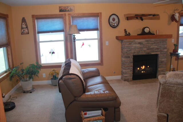 living room featuring baseboards, a fireplace, and light colored carpet