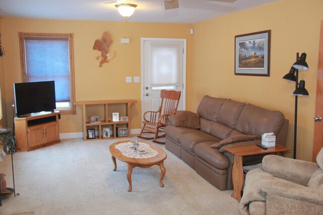 carpeted living room with ceiling fan and baseboards