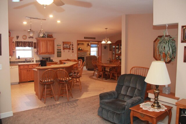 dining space with ceiling fan with notable chandelier and light colored carpet