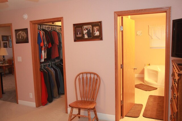 interior space featuring light colored carpet and baseboards