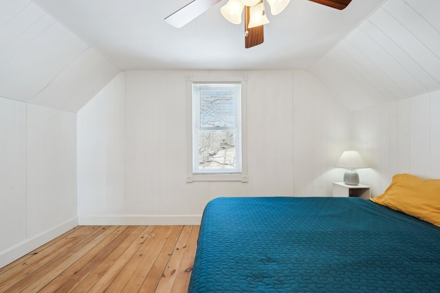 unfurnished bedroom featuring lofted ceiling, ceiling fan, wood finished floors, and baseboards