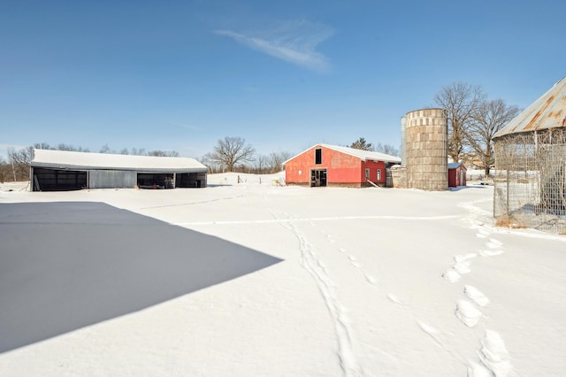 yard layered in snow with an outbuilding