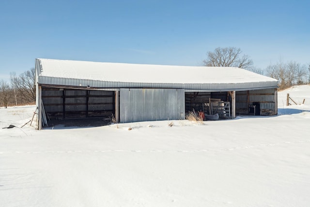 snow covered garage with a detached garage