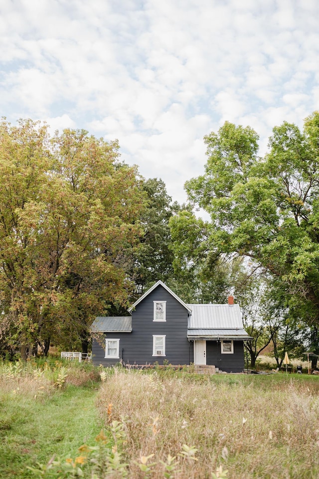 view of front of home featuring metal roof, a standing seam roof, and a chimney