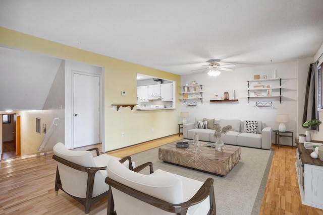 living area with ceiling fan, visible vents, and light wood-type flooring