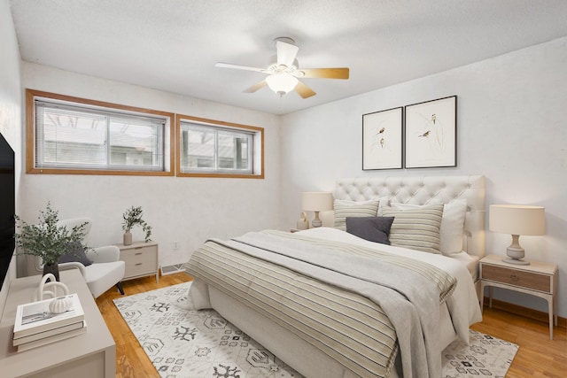 bedroom with multiple windows, a ceiling fan, and light wood-type flooring