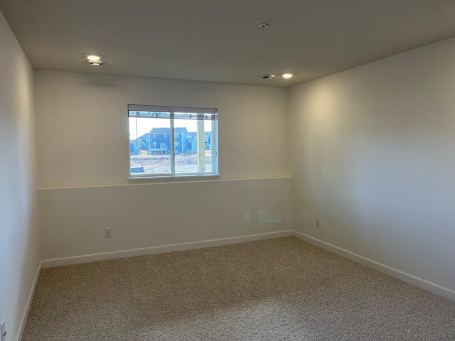 empty room featuring carpet and baseboards