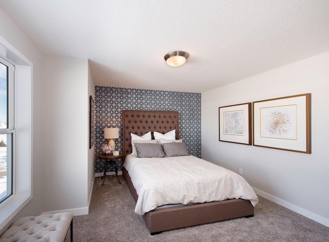 bedroom with an accent wall, carpet floors, baseboards, and wallpapered walls