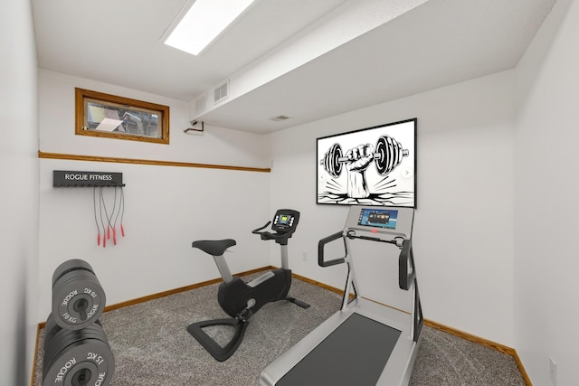 exercise area with visible vents, carpet, and baseboards