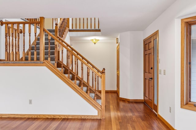 stairway featuring baseboards and wood finished floors