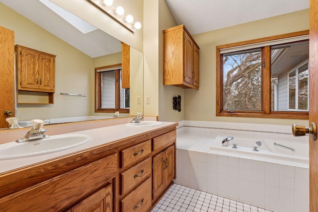 full bathroom featuring lofted ceiling with skylight, tile patterned flooring, a bath, and a sink