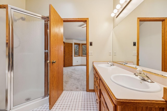 bathroom with double vanity, a stall shower, and a sink