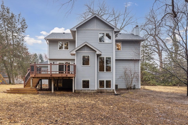 back of house featuring a wooden deck, a shingled roof, a chimney, and stairway