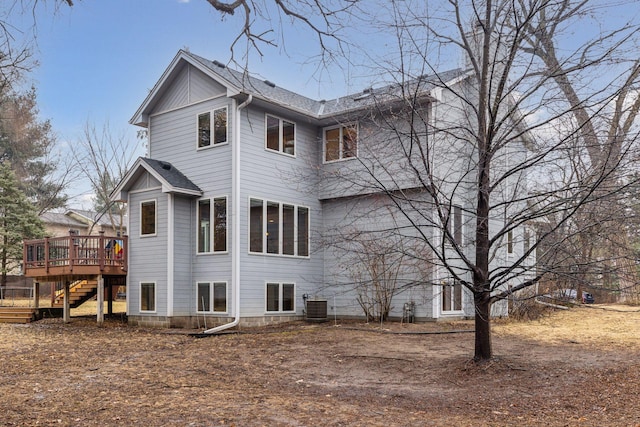 back of house featuring cooling unit, a wooden deck, stairs, and a shingled roof