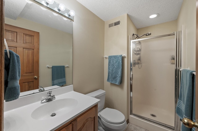 bathroom featuring a textured ceiling, toilet, visible vents, vanity, and a shower stall