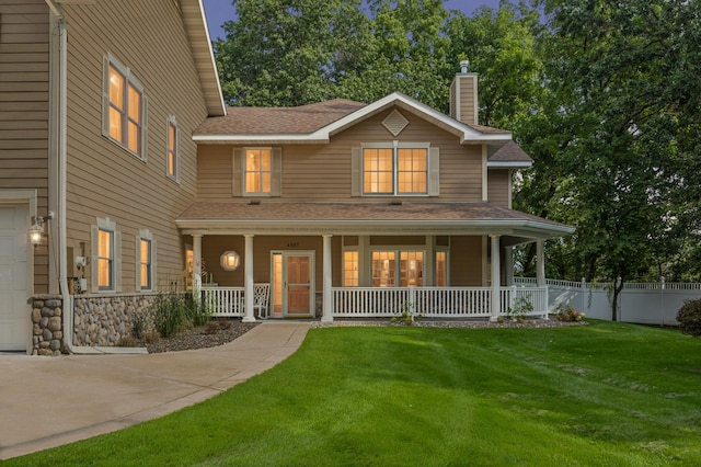 back of property featuring covered porch, a yard, and a garage