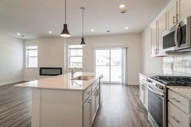 kitchen with an island with sink, white cabinetry, appliances with stainless steel finishes, and light countertops