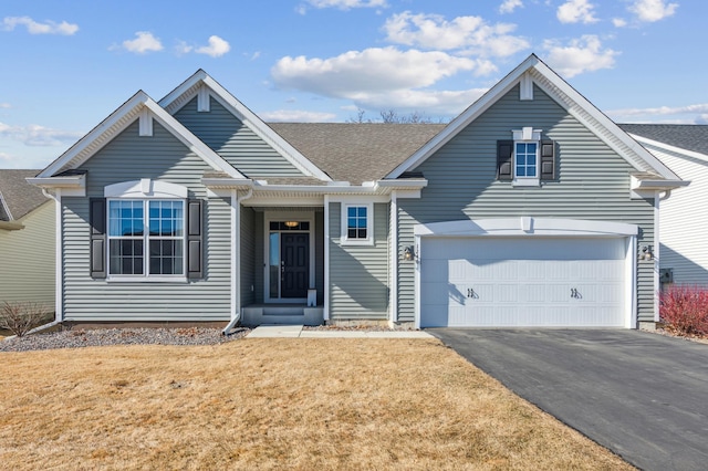 view of front of property featuring a garage, roof with shingles, driveway, and a front lawn