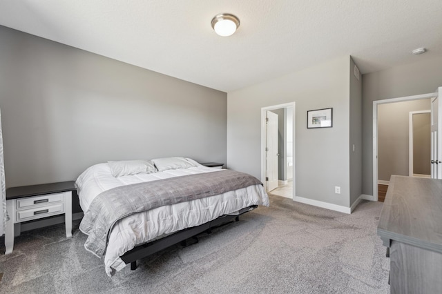 carpeted bedroom with a textured ceiling and baseboards