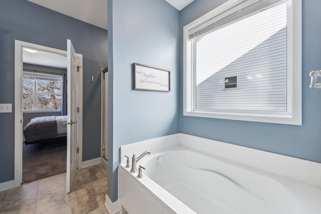 ensuite bathroom with a stall shower, baseboards, a garden tub, and ensuite bath