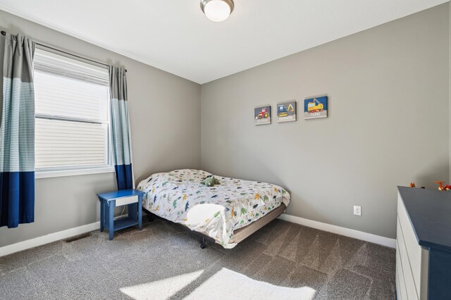 bedroom with carpet floors, visible vents, and baseboards