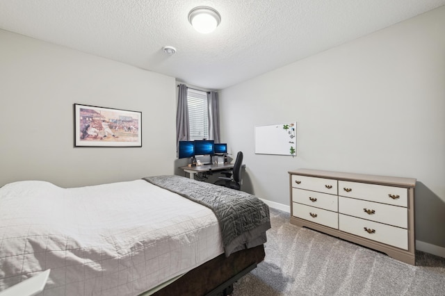 carpeted bedroom with baseboards and a textured ceiling