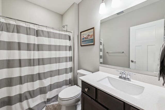 full bath featuring toilet, vanity, visible vents, and a shower with curtain