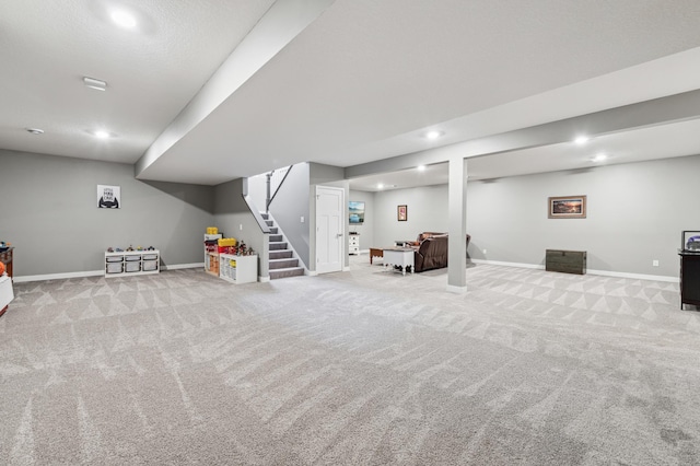 finished basement featuring carpet, baseboards, and stairs