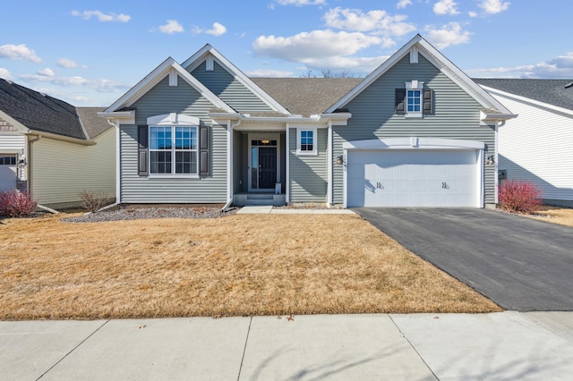 single story home with aphalt driveway, a front lawn, and a garage