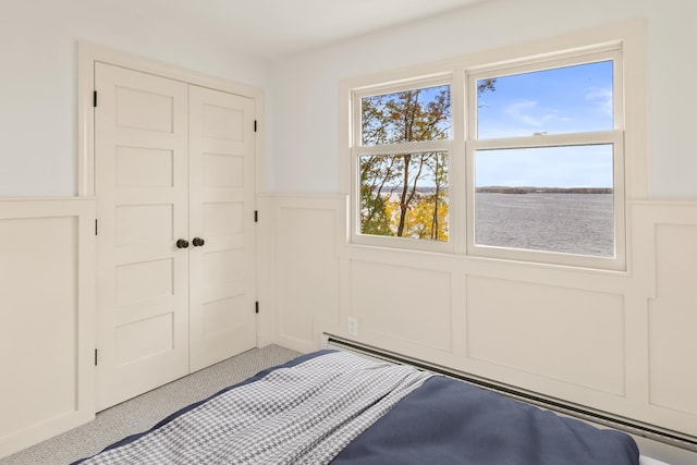 unfurnished bedroom with a closet, a wainscoted wall, a decorative wall, and carpet flooring