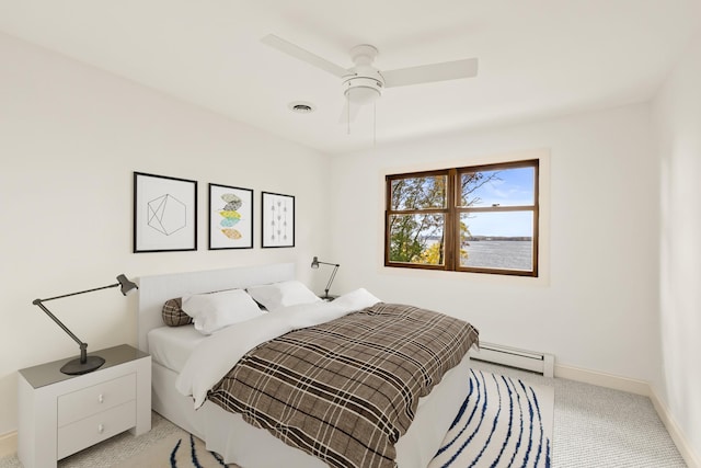bedroom with ceiling fan, light colored carpet, baseboards, a baseboard radiator, and visible vents