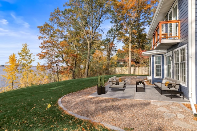 view of yard with fence, outdoor lounge area, a balcony, and a patio area