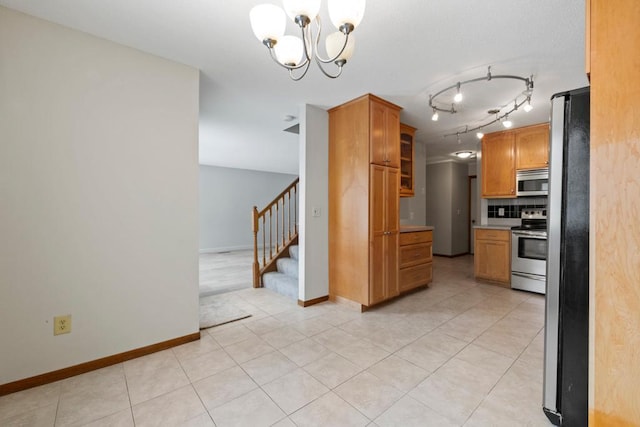 kitchen with brown cabinets, tasteful backsplash, light countertops, appliances with stainless steel finishes, and glass insert cabinets