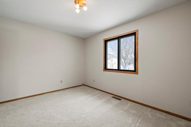 carpeted empty room with visible vents and baseboards