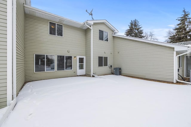 snow covered rear of property with central AC