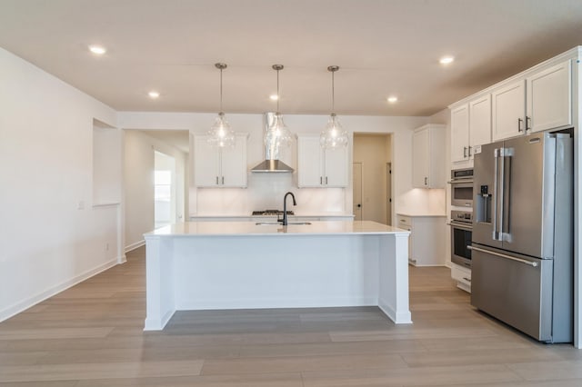 kitchen featuring white cabinetry, a center island with sink, high quality fridge, sink, and pendant lighting