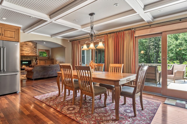 6388 Jasmine Ave N, Stillwater, MN 55082 - dining area with coffered ceiling, hardwood / wood-style floors, beam ceiling, a stone fireplace, and crown molding