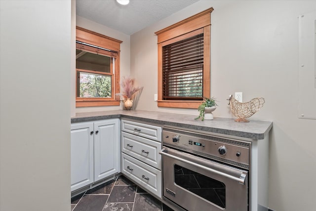 6388 Jasmine Ave N, Stillwater, MN 55082 - kitchen with oven, dark marble finish floors, white cabinetry, and a textured ceiling