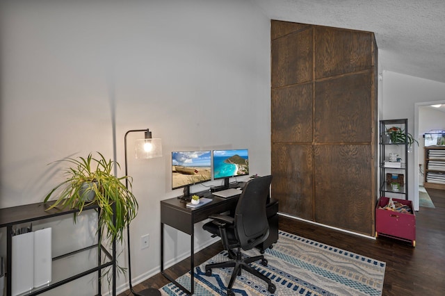 office area with dark wood-type flooring, lofted ceiling, a textured ceiling, and baseboards