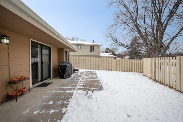 yard layered in snow featuring a fenced backyard