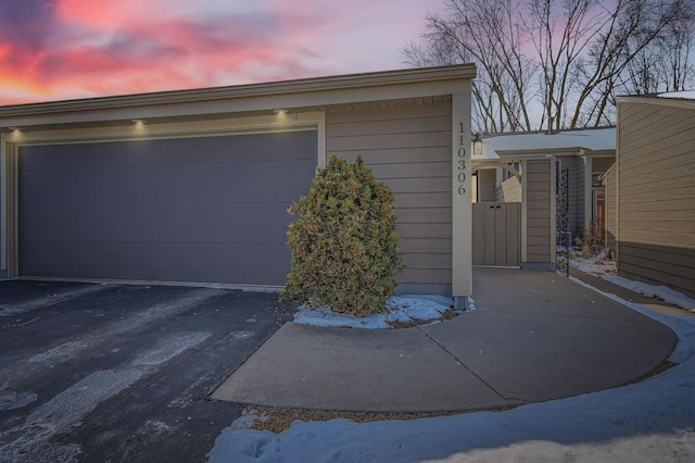 garage at dusk featuring driveway