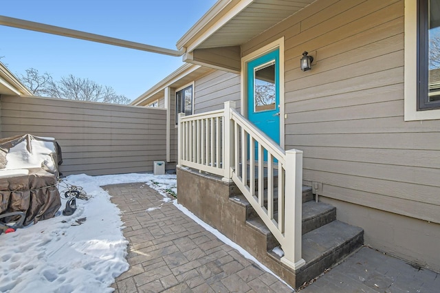 snow covered property entrance with fence