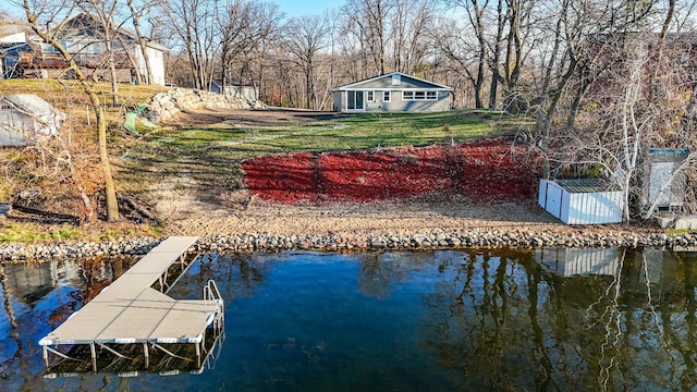 dock area featuring a lawn and a water view