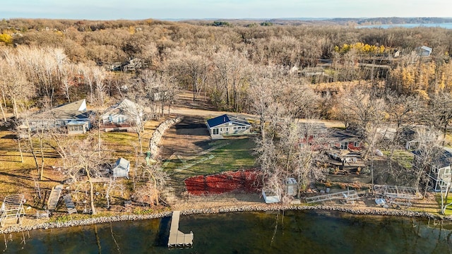 drone / aerial view with a water view and a forest view