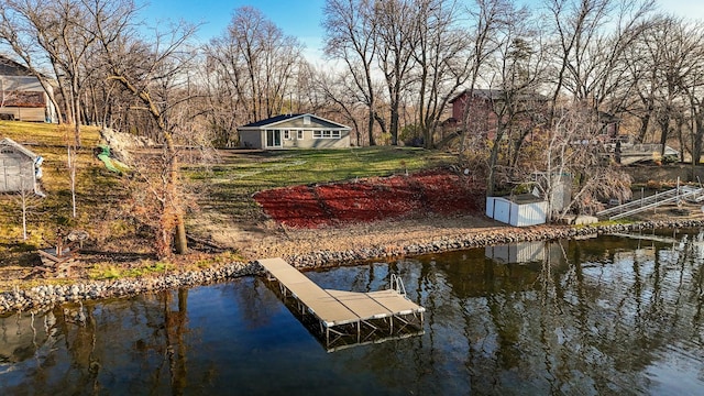 view of dock featuring a lawn and a water view