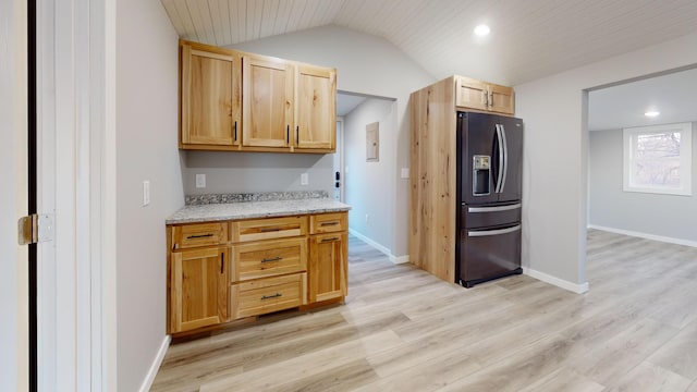 kitchen featuring light wood finished floors, black refrigerator with ice dispenser, lofted ceiling, and baseboards