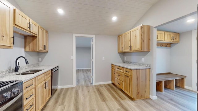 kitchen featuring range with gas cooktop, light wood-style flooring, stainless steel dishwasher, light brown cabinets, and a sink